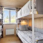 Zimmer mit zwei Stockbetten, Fenster und Heizung.