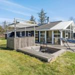 Haus mit Terrasse, Hängematten und Grillplatz im Garten.