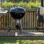 Außenbereich mit Grill und Ofen auf Holzterrasse.