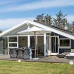 Moderne Villa mit Terrasse, Sonnenschirm und Garten. Holzterrasse mit Sitzgelegenheiten.