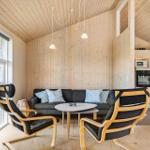 Wohnbereich mit Sofa, zwei Sessel und Küchenzeile