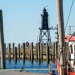 Hafen mit Leuchtturm und Boot im Hintergrund