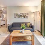 Wohnzimmer mit Sofa, Couchtisch und Blick auf Balkon.