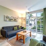 Wohnzimmer mit Sofa, Couchtisch und Balkonansicht