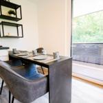 Essbereich mit Tisch und Stühlen, große Fensterfront mit Blick auf Balkon.