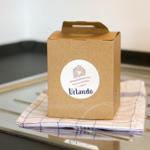 Karton mit Logo steht auf Küchenhandtuch.