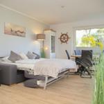 Schlafzimmer mit Schlafcouch, Tisch und Stühlen, Wandbild und Segelruder.