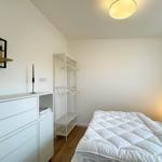 Schlafzimmer mit weißem Bett, Kleiderschrank und Garderobe.