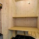 Sauna mit Holzwand, Sitzbank und Heizung.