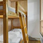Zimmer mit Holzbett, Fenster und Tür