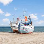 Zwei Fischerboote liegen am Strand. Ein Boot trägt HM70, das andere HM83.