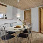 Esszimmer mit Holzboden, Tisch und Stühlen, Fenster und Tür.