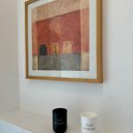 Ein Bild mit Holzrahmen hängt über zwei Tassen mit der Aufschrift GOOD MORNING.