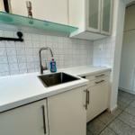 Küche mit Spüle, Arbeitsfläche und Schränken