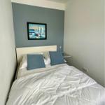 Schlafzimmer mit Bett, Kissen und Wandbild