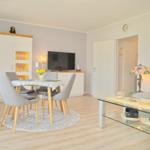 Wohn- und Essbereich mit Sofa, Esstisch und Fernseher.