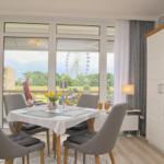 Essbereich mit Tisch und Stühlen. Durch Fenster Blick auf Riesenrad.