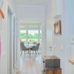 Flur mit Garderobe, Küchenzeile und Blick in Esszimmer mit Tisch und Stühlen.