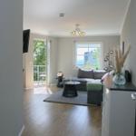 Wohnzimmer mit Sofa, Tisch und Fensterblick auf Meer