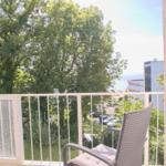 Balkon mit Stuhl und Blick auf Bäume und Meer