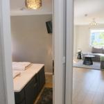 Schlafzimmer mit Bett und Wohnzimmer mit Sofa und Fenster.