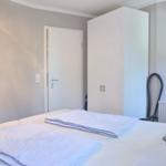 Schlafzimmer mit Bett, Kleiderschrank und Saugrohr.