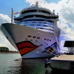 Großes Kreuzfahrtschiff am Hafen mit moderner Anlegestelle.