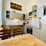 Küche mit Essbereich, Holztisch, zwei Stühlen und moderner Ausstattung.