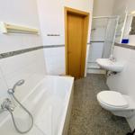 Badezimmer mit Badewanne, Dusche, Waschbecken und Toilette.