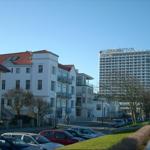 Hotel Neptun und umliegende Gebäude mit Parkplatz und Bäumen.