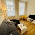 Wohnzimmer mit Sofa, Fernseher und Holzboden.