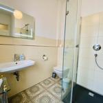 Badezimmer mit Dusche, Waschbecken und Toilette.