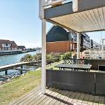 Terrasse mit Sitzgelegenheiten und Blick auf den Hafen.