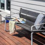 Holzterrasse mit Bank, Kissen und Zeitschrift