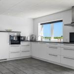 Moderne Küche mit Blick auf Wasser und Grünfläche.