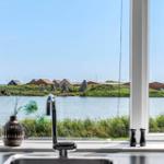 Küchenfenster mit Blick auf Wasser und gegenüberliegende Gebäude.