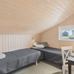 Zimmer mit zwei Betten, Holzwand und Fensterblick.