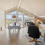 Wohn- und Essbereich mit großem Fenster, Sofa, TV und Esstisch.