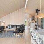 Wohn- und Essbereich mit Holzwänden, Sofa, Esstisch und Kamin.