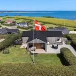 Haus mit Flagge, Terrasse und Blick auf Meer und Grünflächen