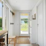 Helle Eingangshalle mit Tür zur Terrasse und Küchenbereich.