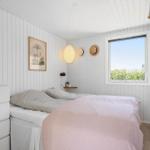 Schlafzimmer mit Bett, Fenster und Wanddekoration.