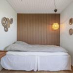 Schlafzimmer mit Bett, Nachttisch, Kleiderschrank und Wanddekoration.