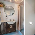 Badezimmer mit Waschbecken, Spiegel, Dusche und Toilette.