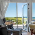 Raum mit Sessel, Kamin und Blick auf das Meer.