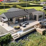 Moderne Holzhütte mit großem Balkon, Whirlpool und Garten.