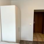 Schlafzimmer mit Kleiderschrank und Tür zum Flur.