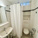 Badezimmer mit Dusche, Toilette und Waschbecken.