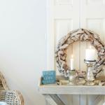 Holztablett mit Kerzen, Kranz und Schild vor Tür