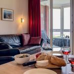 Wohnbereich mit Sofa, Stuhl und Tisch mit Wein und Käse.